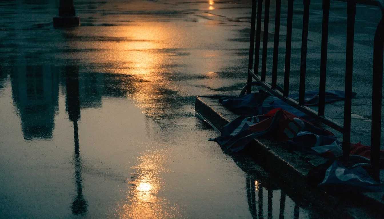A rain-wet street at night with amber light on the asphalt after a late campaign gathering
