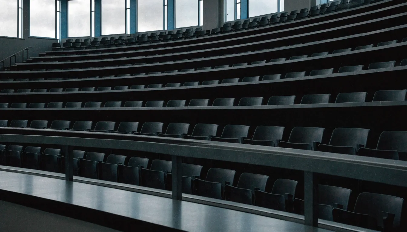 An empty tiered assembly chamber photographed from the gallery rail at dusk